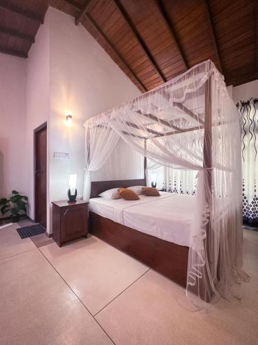 a bedroom with a canopy bed in a room at Serene View Lodge in Unawatuna