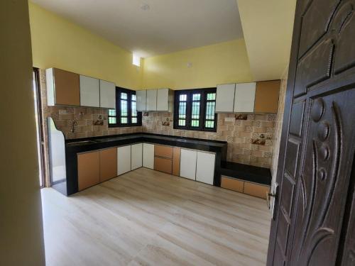 a large kitchen with white and brown cabinets and a door at Golden in Kaup