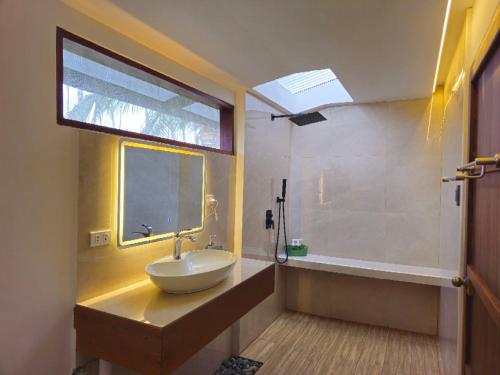 a bathroom with a sink and a tub and a window at BAIBAI Long Beach in New Agutaya