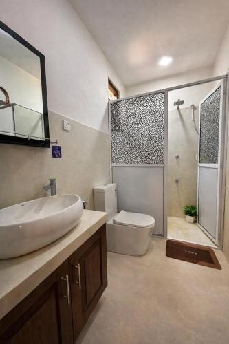 a bathroom with a sink and a toilet and a shower at Serene View Lodge in Unawatuna