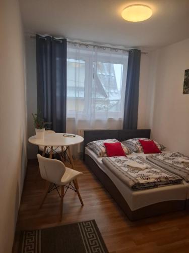 a bedroom with a bed and a table and a window at Na Górce W Białym Dunajcu in Biały Dunajec