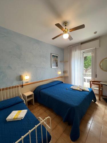 a bedroom with two beds and a ceiling fan at Hotel Villa dei Fiori - sul mare con piscina in Rimini