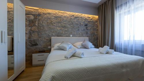 a bedroom with a large bed with white pillows at House Vidovic by Villas Guide in Mlinište