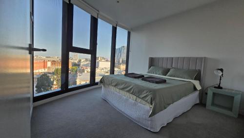 a bedroom with a large bed and large windows at FV 1BR APT with Rooftop Pool in Brisbane