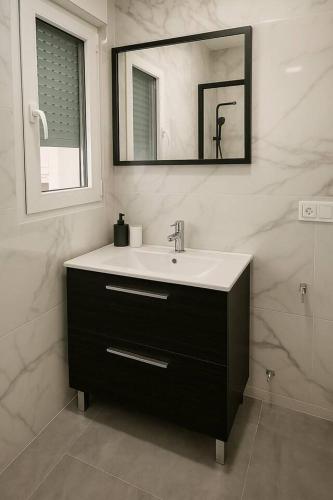 a bathroom with a sink and a mirror at Alojamiento Baeza - Chicharro in Baeza