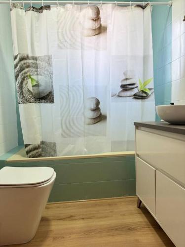 a bathroom with a toilet and a shower curtain at Alojamiento Baeza- El Limonero A in Baeza