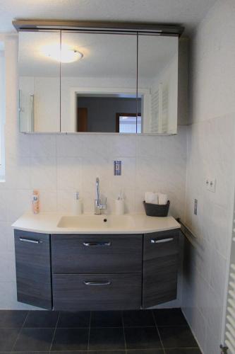 a bathroom with a sink and a mirror at Ola Sauerland in Brilon
