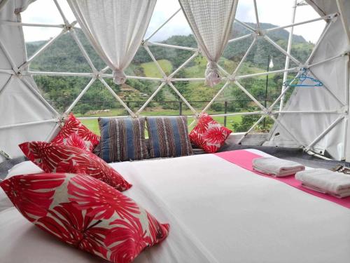 een bed in een kamer met een glazen wand bij เวนิสบ้านเวร โดมใส in Ban Khun Nam Nan