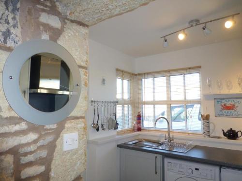 a kitchen with a sink and a mirror on the wall at 1 Bed in Seahouses oc-cn123 in Seahouses
