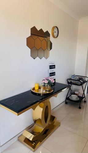 a table in a room with a clock on the wall at Cozy home close to Perth's first Starbucks in Perth