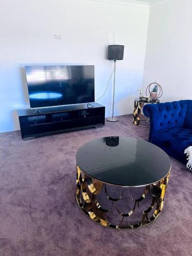 a living room with a coffee table and a tv at Cozy home close to Perth's first Starbucks in Perth