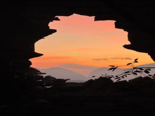 een silhouet van een grot met een zonsondergang op de achtergrond bij Apartment in a farmhouse with 2 swimming pools in Cagli
