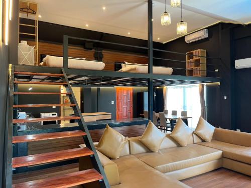 een woonkamer met een bank en een stapelbed bij Khao Lak - Loft Suite with 2 king size beds, bathroom with bathtub in Khao Lak