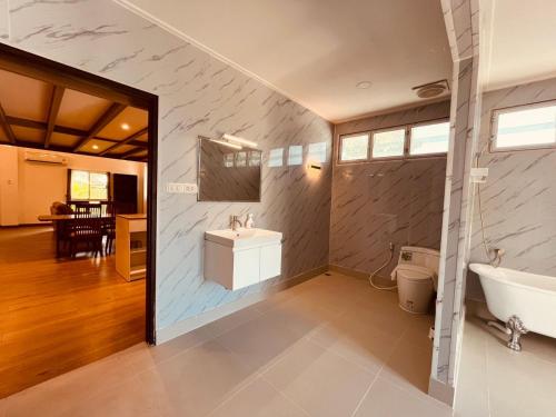 een badkamer met een wastafel en een ligbad bij Khao Lak - Loft Suite with 2 king size beds, bathroom with bathtub in Khao Lak