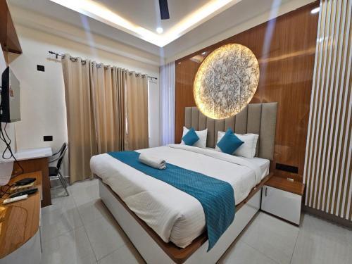 a bedroom with a large bed with a blue blanket at Hotel Sai Paradise in Lucknow