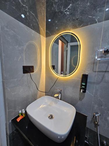a bathroom with a white sink and a mirror at Hotel Sai Paradise in Lucknow