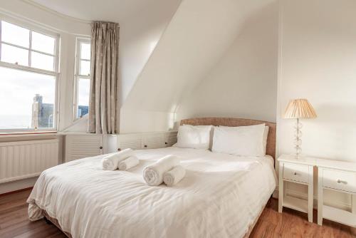 a white bedroom with two towels on a bed at Overton - Elie in Elie