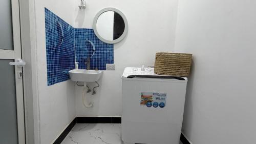 ein kleines Badezimmer mit Waschbecken und Spiegel in der Unterkunft Hakunamatata studio in Zanzibar City