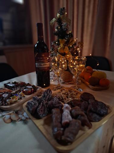 a table with a bottle of wine and a plate of food at Cottage Mountain crystal kazbegi in Stepantsminda