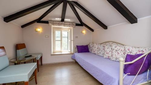 een woonkamer met een paarse bank en een raam bij Villa Dia by Villas Guide in Dubrovnik