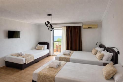 een hotelkamer met twee bedden en een raam bij Porto Matina in Metamorfosi