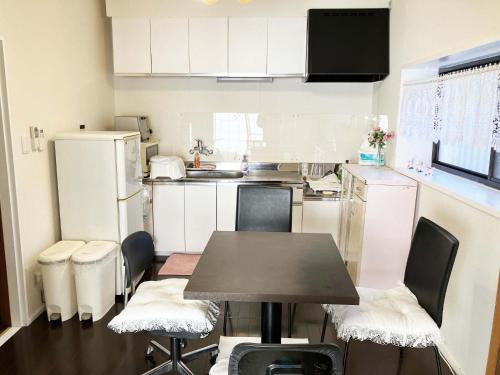 una piccola cucina con tavolo e sedie di The Village House 1 a Hadano
