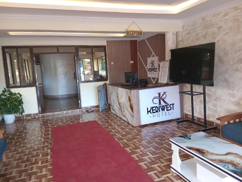 een woonkamer met een televisie en een tafel bij Keriwest hotel in Kericho