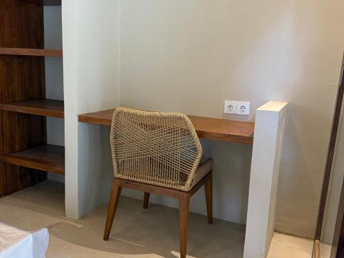 een rieten stoel voor een houten bureau bij ZENARA lombok in Kuta Lombok