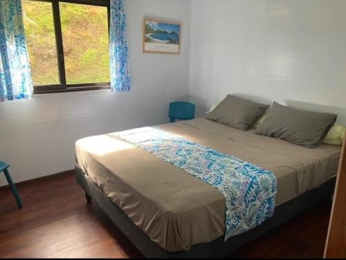 una camera da letto con un letto in una stanza con una finestra di Te Fare Ninamu a Taputapuapea