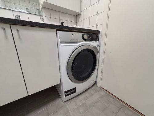 a washer and dryer in a white kitchen at Central in Vika in Oslo