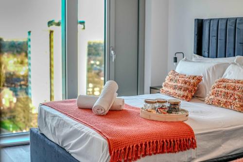 a bed with a tray of food and candles on it at 1-BR Flat in Eccles - 1 Minute Walk to Train & Tram Station - Sleeps 3 in Manchester