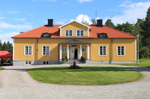 una gran casa amarilla con techo naranja en Bjurfors Hotell & Konferens, en Avesta