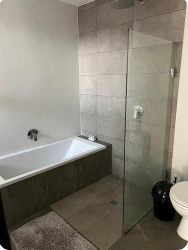 a bathroom with a bath tub and a toilet at Three Waves in Ballito