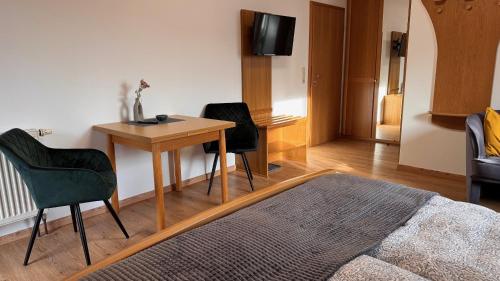 una stanza con un tavolo, due sedie e una televisione di Haus am Heubach a Bad Staffelstein