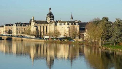 a large building next to a body of water at Le Ptit nid in Château-Gontier