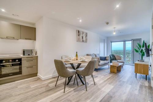 a kitchen and living room with a table and chairs at 2-BR Near Salford Royal - City & Town Centre View - 1 Minute to Train & Tram Station - Sleeps 6 in Manchester