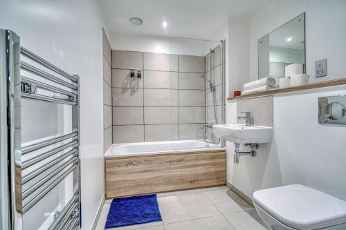 a bathroom with a tub and a toilet and a sink at 2-BR Near Salford Royal - City & Town Centre View - 1 Minute to Train & Tram Station - Sleeps 6 in Manchester