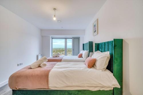 a bedroom with a large bed with a large window at 2-BR Near Salford Royal - City & Town Centre View - 1 Minute to Train & Tram Station - Sleeps 6 in Manchester