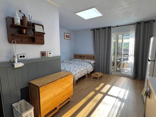 a small bedroom with a bed and a window at Miru House in Seogwipo