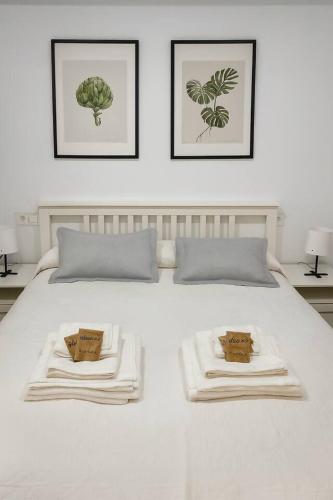 a white bed with two towels on top of it at Alojamiento Baeza California 4B in Baeza