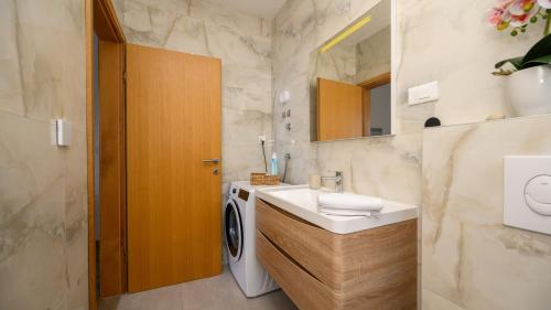 a bathroom with a sink and a washing machine at Villa Dida Bozo by Villas Guide in Blace