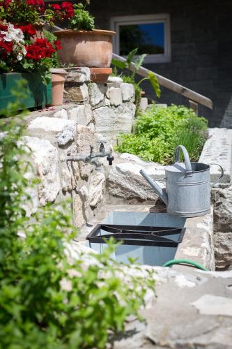 a garden with a bucket on a stone wall at Villa Marienhof in Annenheim