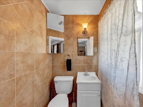 a bathroom with a toilet and a shower curtain at Oasis of Atlanta in Atlanta
