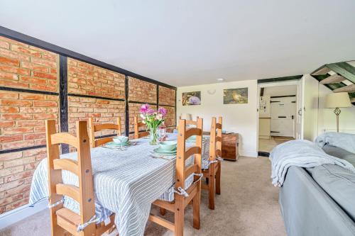 a dining room with a table and a brick wall at Mill View in Harpley