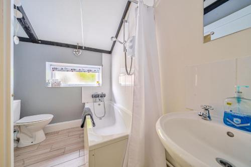 a bathroom with a sink and a toilet and a tub at Mill View in Harpley