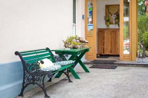 a green bench with a table next to a door at Villa Marienhof in Annenheim