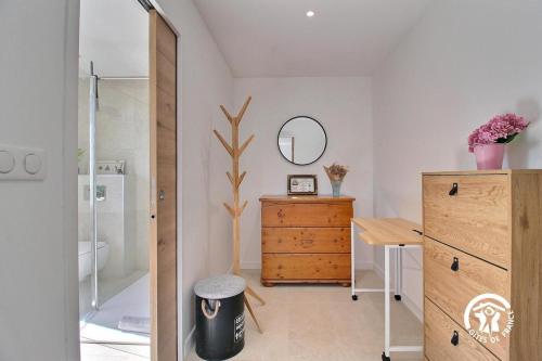 a bathroom with a wooden dresser and a mirror at Ty bayon in Belz