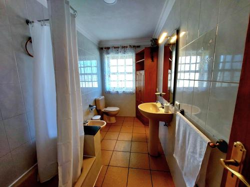 een badkamer met 2 wastafels, een toilet en een spiegel bij Peluquina in Barlovento