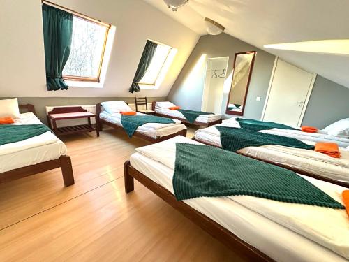 een kamer met 4 bedden met groene en witte lakens bij I&A Residence Humala in Tallinn