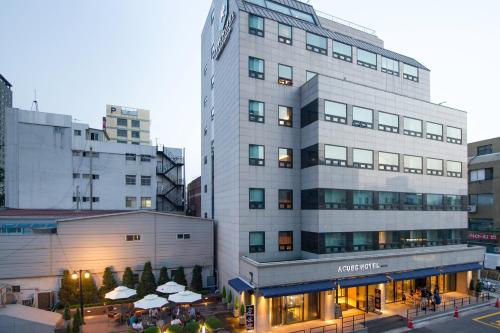 a tall white building with a restaurant in front of it at Acube Hotel Dongdaemun in Seoul